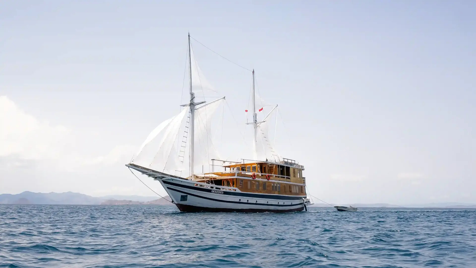Phinisi under full white sail