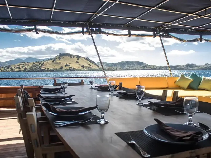 Dining table set on a phinisi deck at anchor