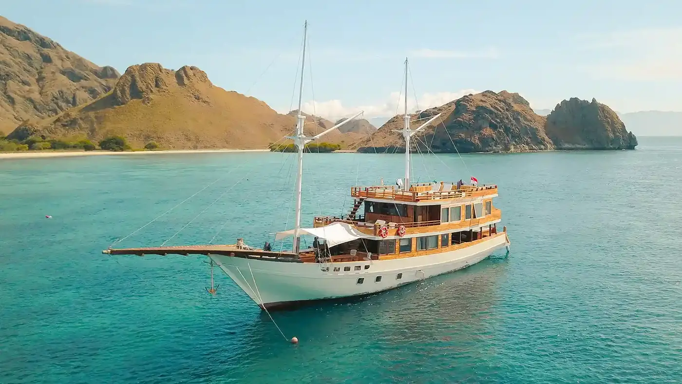 Phinisi anchored in clear turquoise water