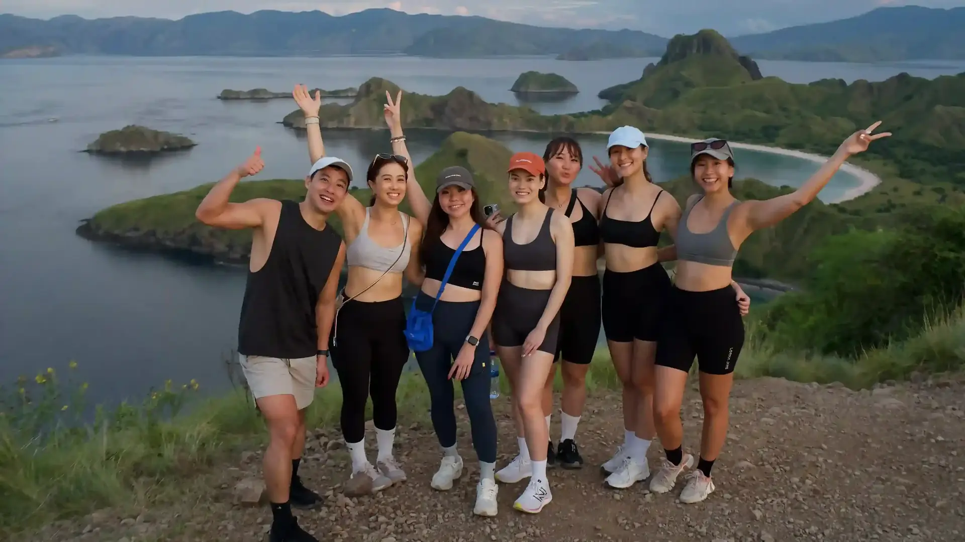 Group of travellers cheering at the Padar Island viewpoint